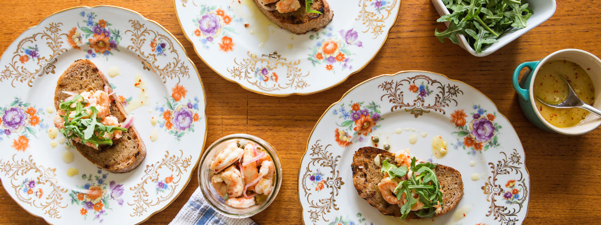 toasted bread with pickled shrimp and arugula
